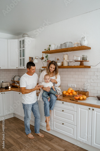 mom and dad play with their son in the kitchen, life style. 