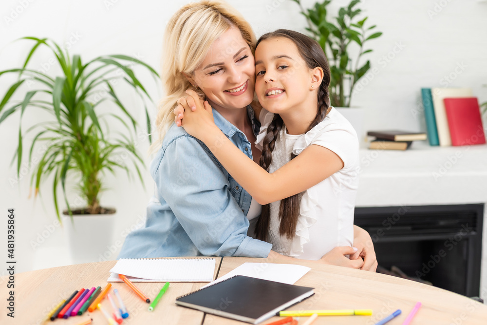 Beautiful school girl doing homework with mother at home Beautiful school girl doing homework with mother at home