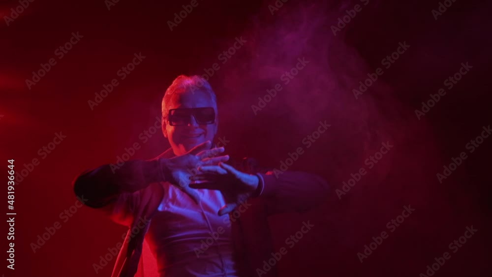 Funny dance. Funky man. Optimistic lifestyle. 80s disco. Excited carefree happy cool male enjoying favorite music in bright red neon light smoke flow. Funny dance. Funky man. Optimistic lifestyle. 80s disco. Excited carefree happy cool male enjoying favorite music in bright red neon light smoke flow.