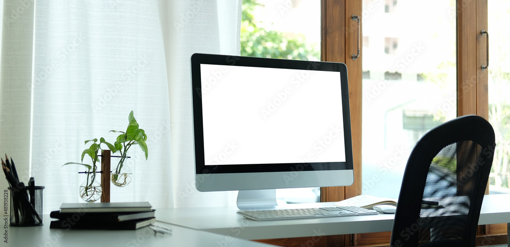 Comfortable workplace with computer, houseplant books and office supplies. Blank screen for your advertising text. Comfortable workplace with computer, houseplant books and office supplies. Blank screen for your advertising text.