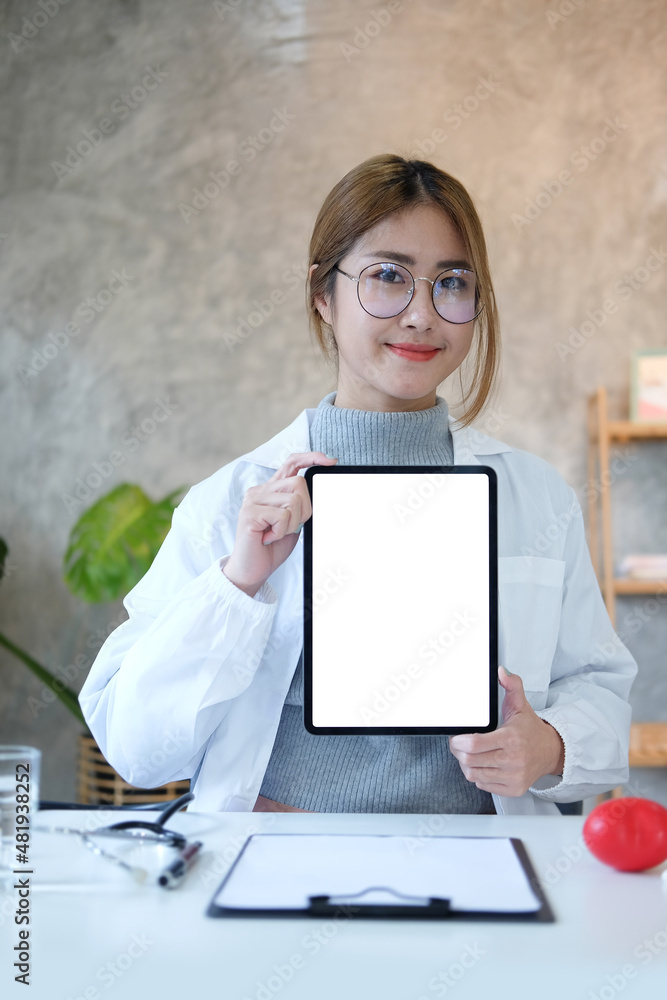 Portrait of asian female doctor holding mock up digital tablet and smiling to camera. Blank screen for your advertising text. Portrait of asian female doctor holding mock up digital tablet and smiling to camera. Blank screen for your advertising text.