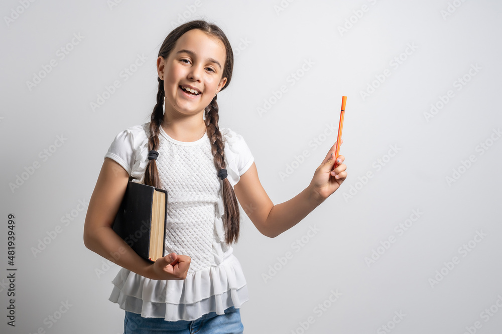 Lovely little girl standing and holding book over white background Lovely little girl standing and holding book over white background