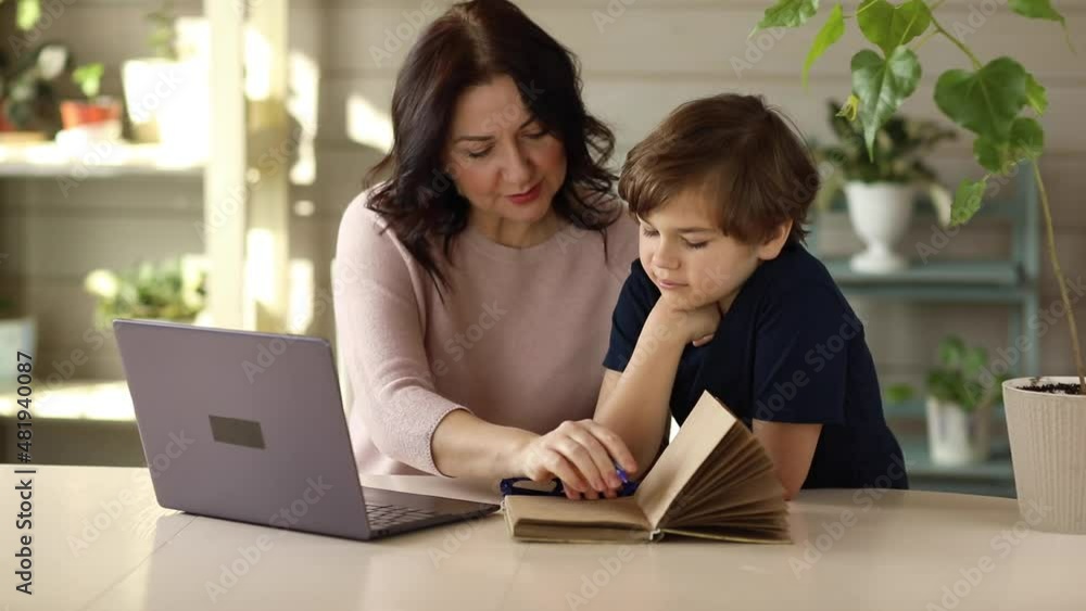 Mom and son are engaged in online school doing tasks Mom and son are engaged in online school doing tasks