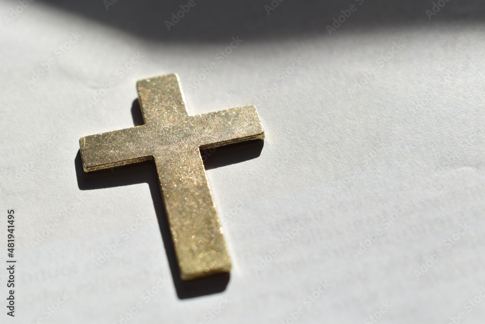 Gold cross on blank white page. 