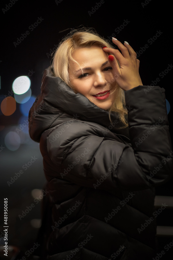 Portrait of a beautiful young girl on the street of a night city with insufficient lighting. Portrait of a beautiful young girl on the street of a night city with insufficient lighting.