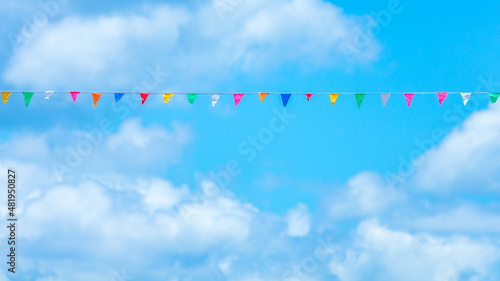 Colorful flag paper with blue sky and cloud background.