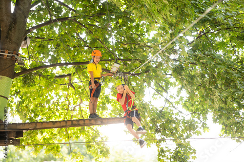 Happy child climbing in the trees. Rope park. Climber child. Early childhood development. Roping park. Balance beam and rope bridges. Rope park - climbing center photo