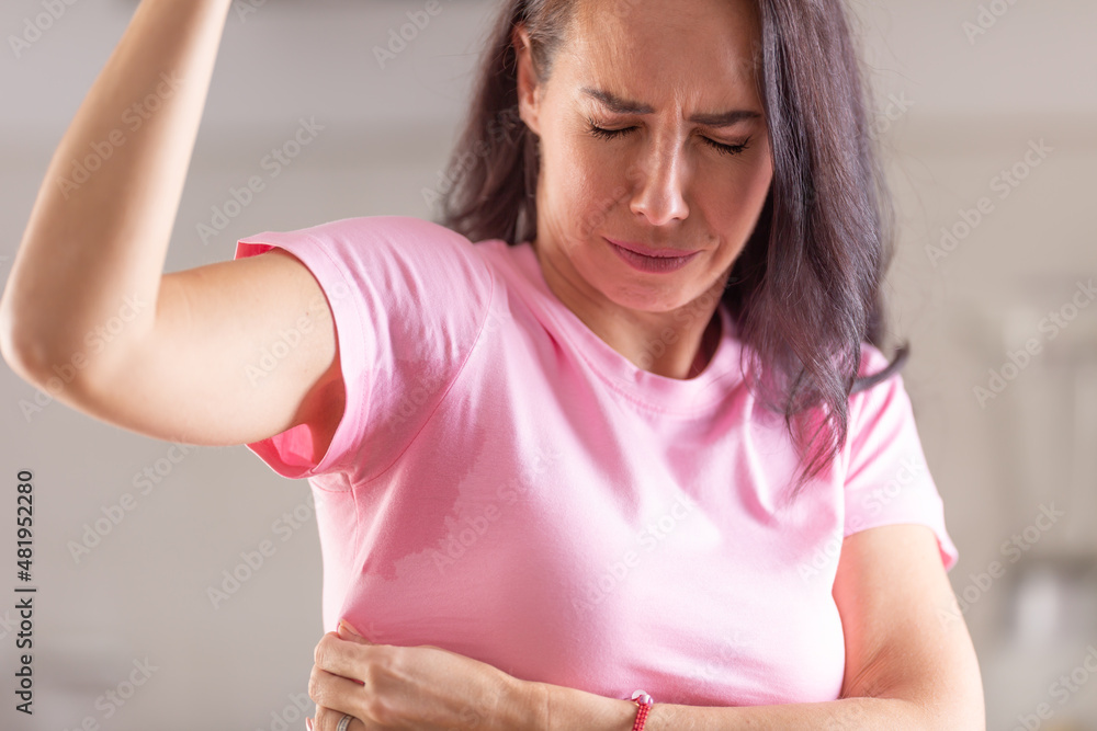 Woman can smell herself as she sweats with sweat patches in her armpits