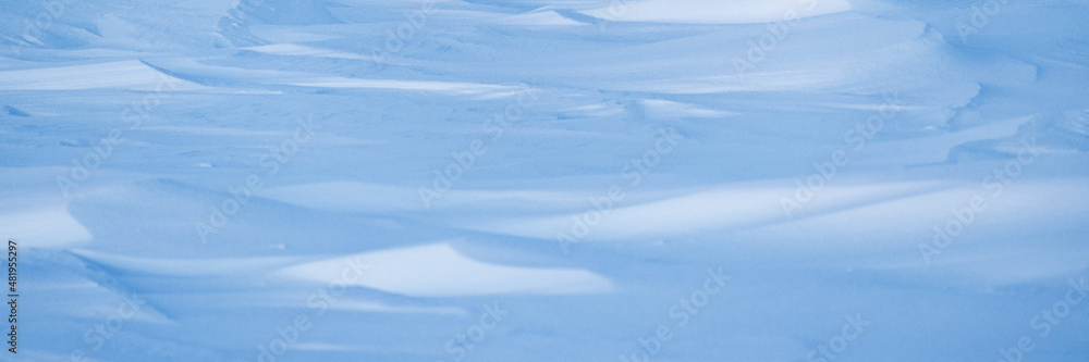 Beautiful winter background with snowy ground. Natural snow texture. Wind sculpted patterns on snow surface. Arctic, Polar region. Beautiful winter background with snowy ground. Natural snow texture. Wind sculpted patterns on snow surface. Arctic, Polar region.