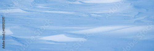 Beautiful winter background with snowy ground. Natural snow texture. Wind sculpted patterns on snow surface. Arctic, Polar region.