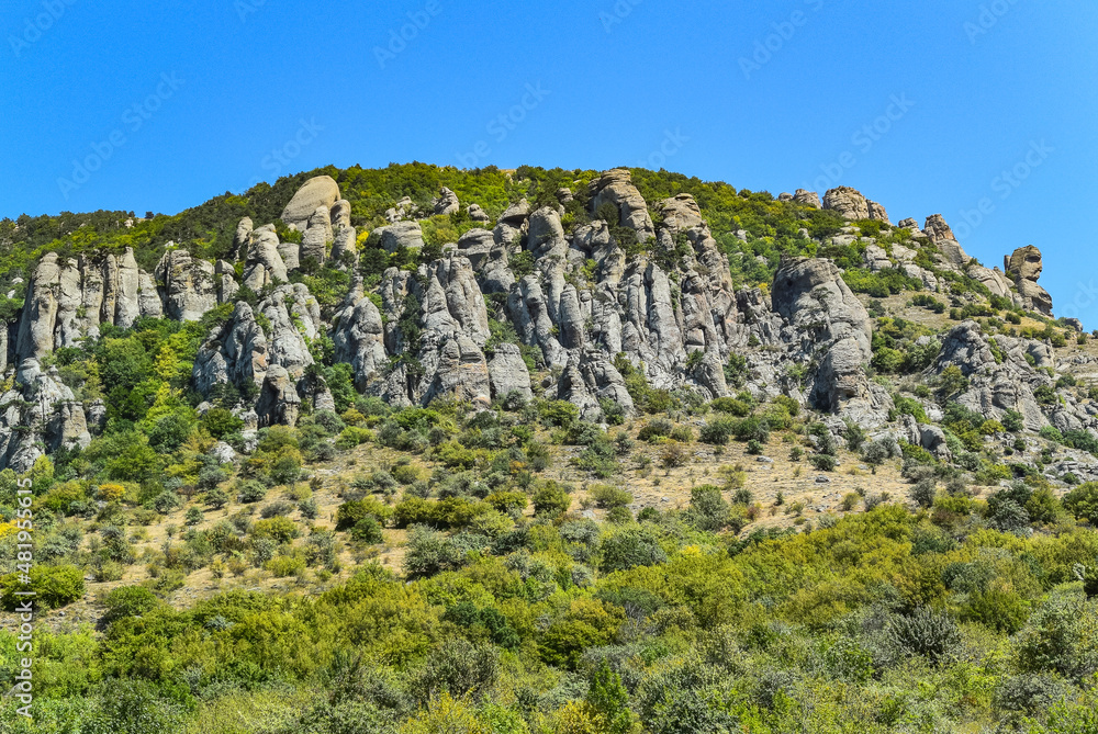 Ancient limestone high mountains of rounded shape in the air haze. The Valley of Ghosts. Demerji. May 2021. Crimea. Russia. Ancient limestone high mountains of rounded shape in the air haze. The Valley of Ghosts. Demerji. May 2021. Crimea. Russia.