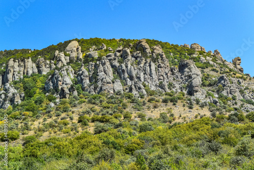 Ancient limestone high mountains of rounded shape in the air haze. The Valley of Ghosts. Demerji. May 2021. Crimea. Russia.