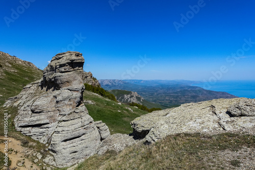 Ancient limestone high mountains of rounded shape in the air haze. The Valley of Ghosts. Demerji. May 2021. Crimea. Russia.