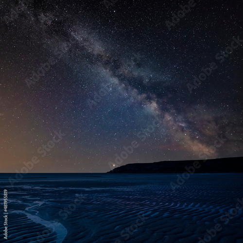 Digital composite image of Milky Way and Epic Absolutely beautiful landscape images of Holywell Bay beach in Cornwall UK