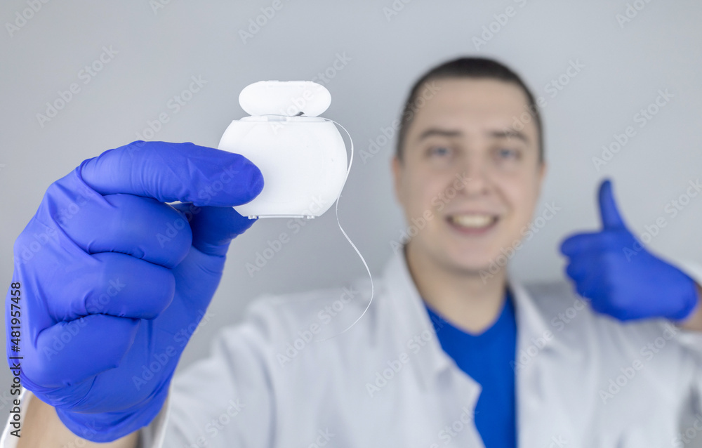 Dental floss close up. Dentist shows how to use the thread correctly