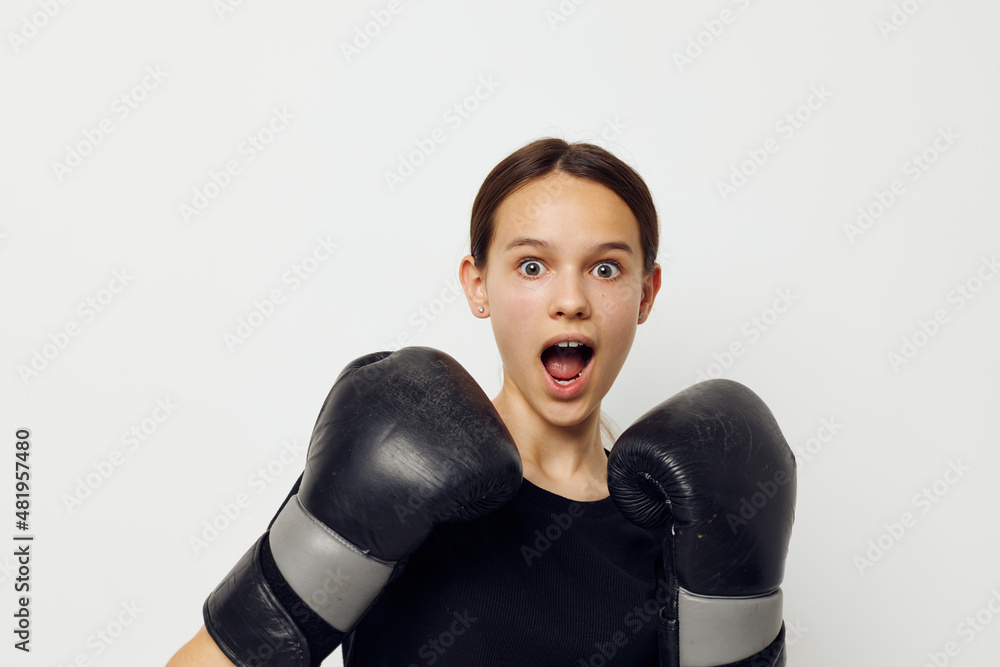 young woman in black sports uniform boxing gloves posing isolated background young woman in black sports uniform boxing gloves posing isolated background