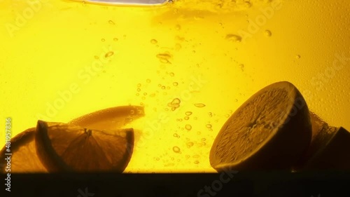 Orange in a glass of juice. Slow motion