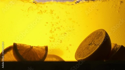 Orange in a glass of juice. Slow motion