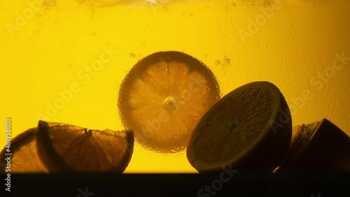 Orange in a glass of juice. Slow motion