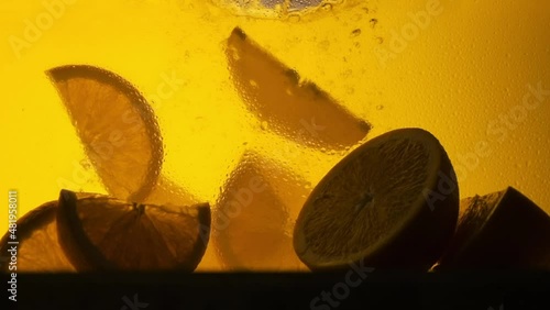 Orange in a glass of juice. Slow motion