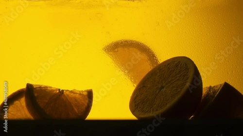 Orange in a glass of juice. Slow motion
