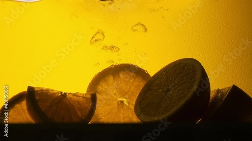Orange in a glass of juice. Slow motion