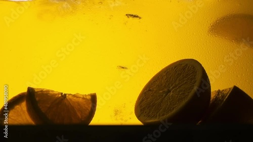 Orange in a glass of juice. Slow motion