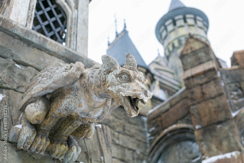 Gargoyle statue attached to the wall of the castle 