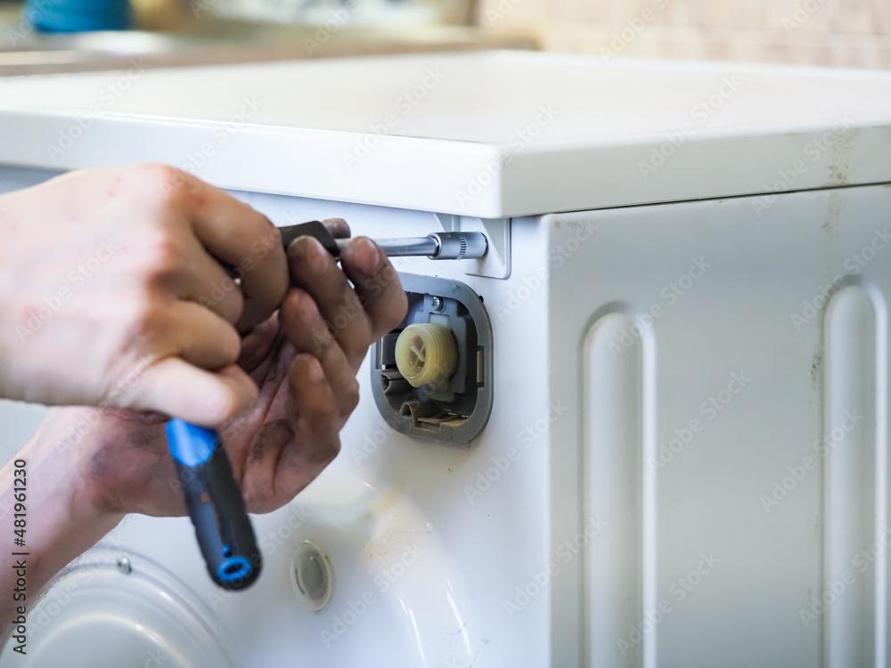 Naklejka premium master man disassembles into a washing machine for repair
