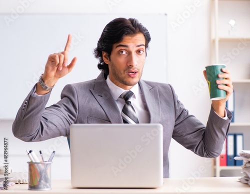 Wallpaper Mural The young handsome businessman employee sitting in the office Torontodigital.ca