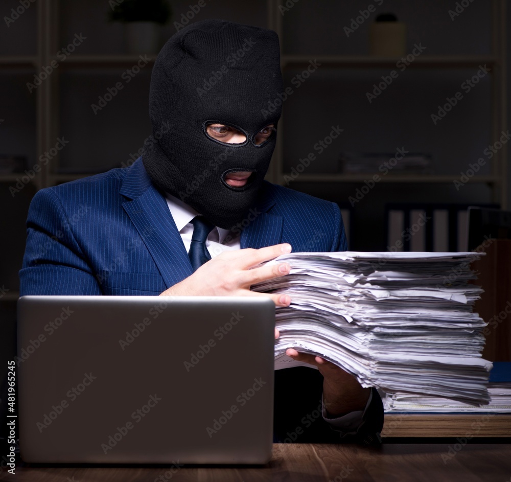 Male employee stealing information in the office night time Male employee stealing information in the office night time