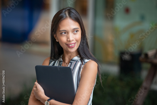 Asian business woman using laptop outdoor.