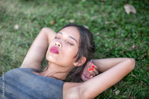 Young and beautiful asian woman in the city park relaxing after daily fitness training.