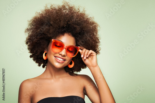 Beauty portrait of African American girl in colored sunglasses. Beautiful black woman. Cosmetics, makeup and fashion