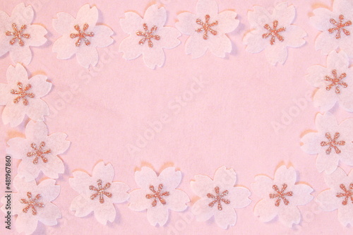 Cherry blossom petals paper crafts on pink textured paper background for wall paper. Blank for copy space.