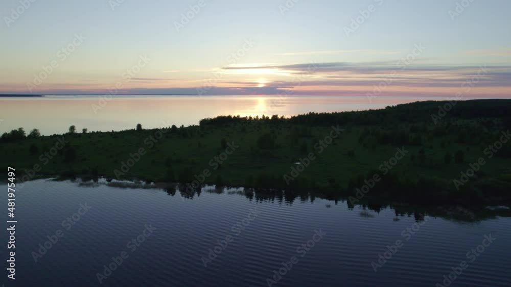 Sunset in lake with small island covered with forest, aerial view Sunset in lake with small island covered with forest, aerial view