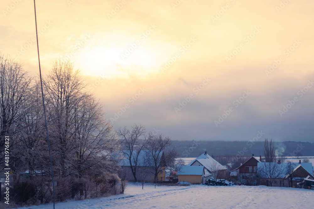 Rural hungarian village covered in snow at sunset