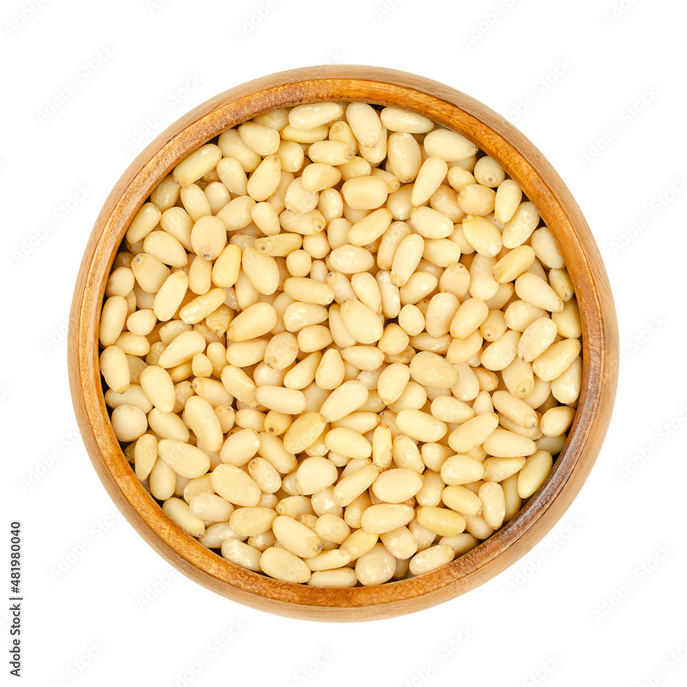 Cedar nuts, pine nuts, harvested in Russia, in a wooden bowl. Edible seeds of Siberian pine, Pinus sibirica, also called pinon, pinoli and pignoli. Used for pesto, added to dishes or baked into bread.