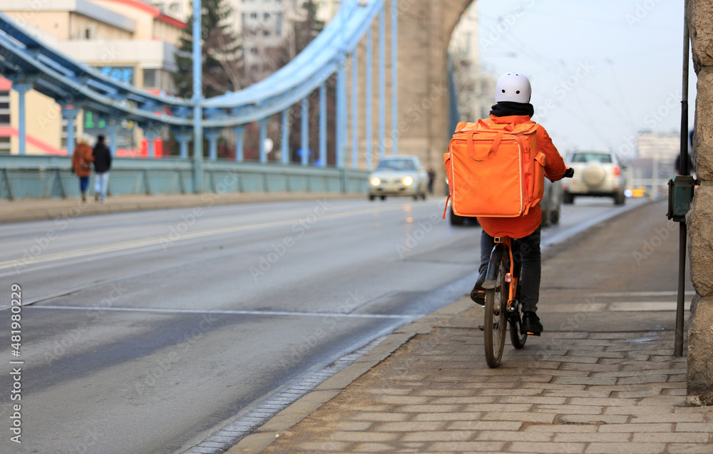 Kurier na rowerze jedzie mostem Grunwaldzkim we Wrocławiu, dostarcza jedzenie.  - obrazy, fototapety, plakaty 
