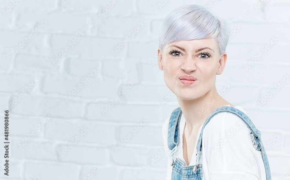 Portrait of grimacing young woman with platinum blonde hair. Portrait of grimacing young woman with platinum blonde hair.
