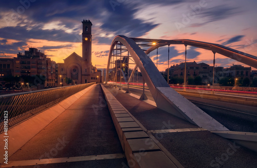 Sunset in Tortosa, church and iron bridge over the Ebro river