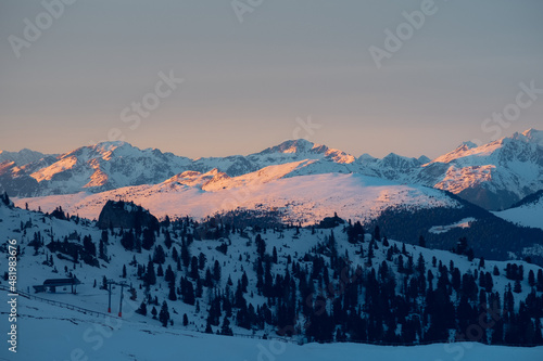 Mountains covered with snow and lit red by the sunset light