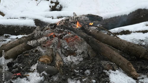 burning bonfire in the winter forest among snowdrifts