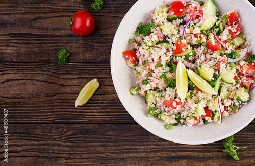 Tabbouleh salad. Traditional middle eastern or arab dish. Levantine vegetarian salad with parsley, cucumber, couscous, tomato. Top view, above