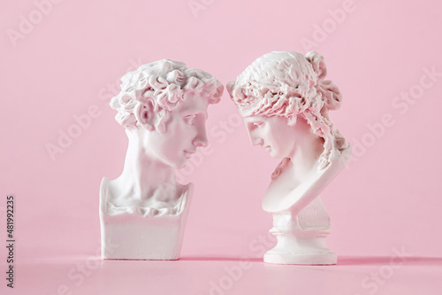 gypsum antique bust of man and woman on pink background, concept of love trust and valentine's day