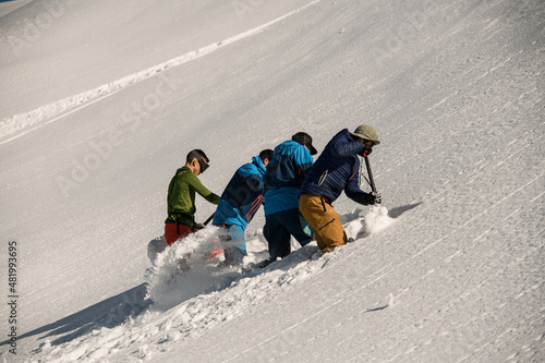 Papier peint men are digging snow and checking the mountain for avalanche safety