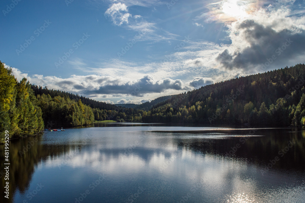 dam with blue sky and clouds on a beautiful day in fall with reflections on water dam with blue sky and clouds on a beautiful day in fall with reflections on water