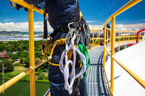 Closeup male worker standing on tank male worker height roof tank knot carabiner rope access photo