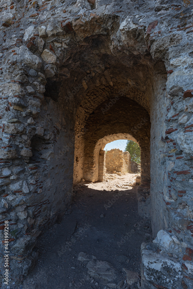 Ruins of stone gate through a thick wall to the ancient Fortress of Villehardouin, Mystras, Greece