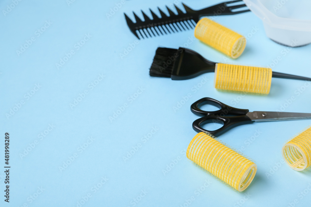 Set of hairdresser's tools and hair curlers on blue background, closeup Set of hairdresser's tools and hair curlers on blue background, closeup